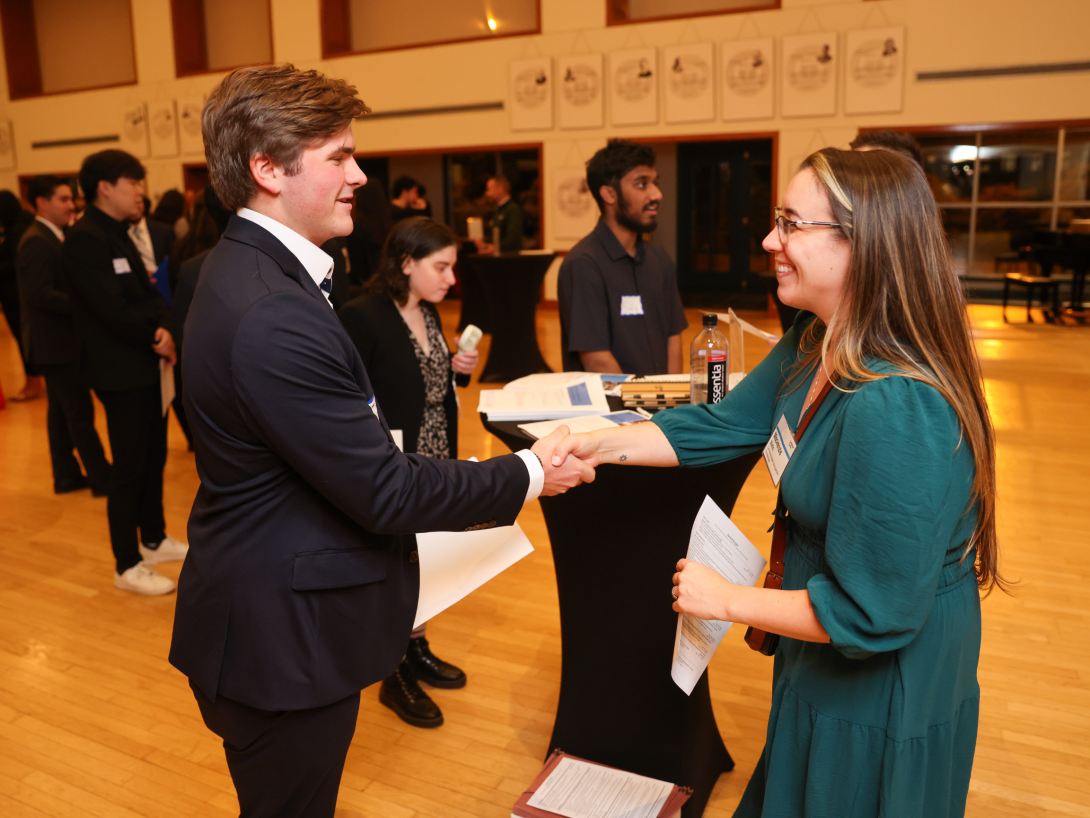 Student shaking hands with potential employer Lally Industry Networking Night Nov. 13